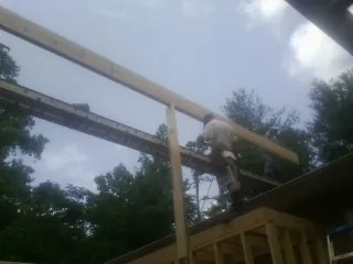 Carpenter setting a ridge beam over a new addition frame — Ice Dam Removal by Roofing Brothers in Mercer